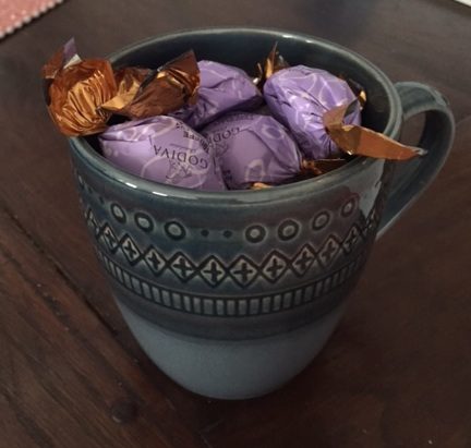This lovely mug was filled with chocolate, but now I had to stuff paper into the bottom because I've eaten most of the candy.